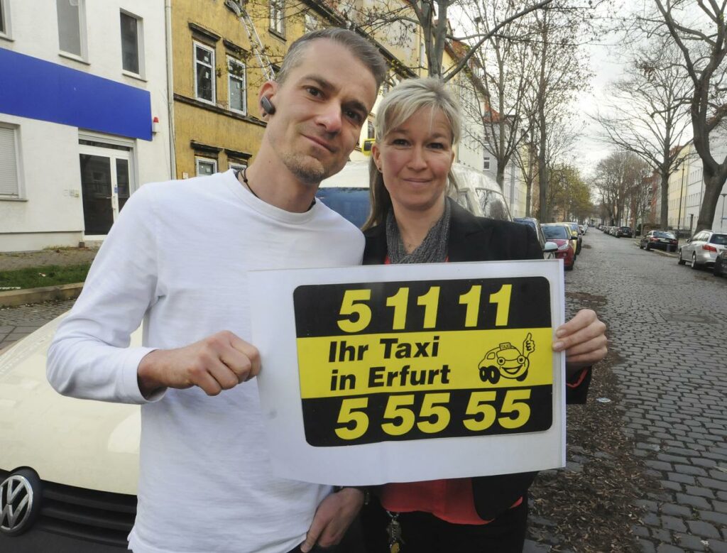 Im Bild von links nach rechts: Daniel Schwuchow, Administrator der Taxizentrale Das City Taxi AG und Michaela John, kaufmännischen Leiterin mit einem Schild des Taxisrufes 5 55 55.