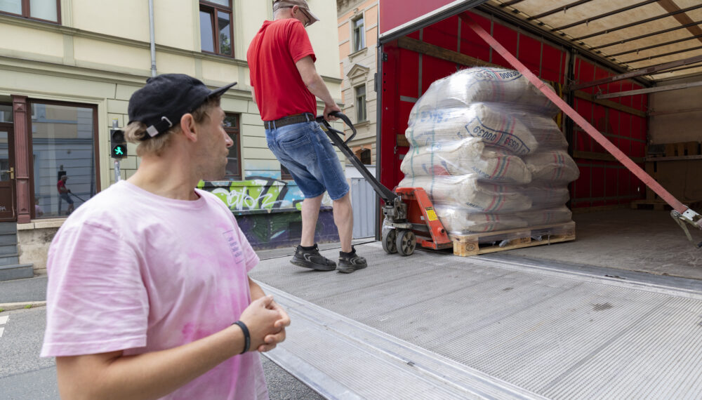 Mitarbeiter bei der Anlieferung von Kaffeesäcken vor der Rösterei in Weimar